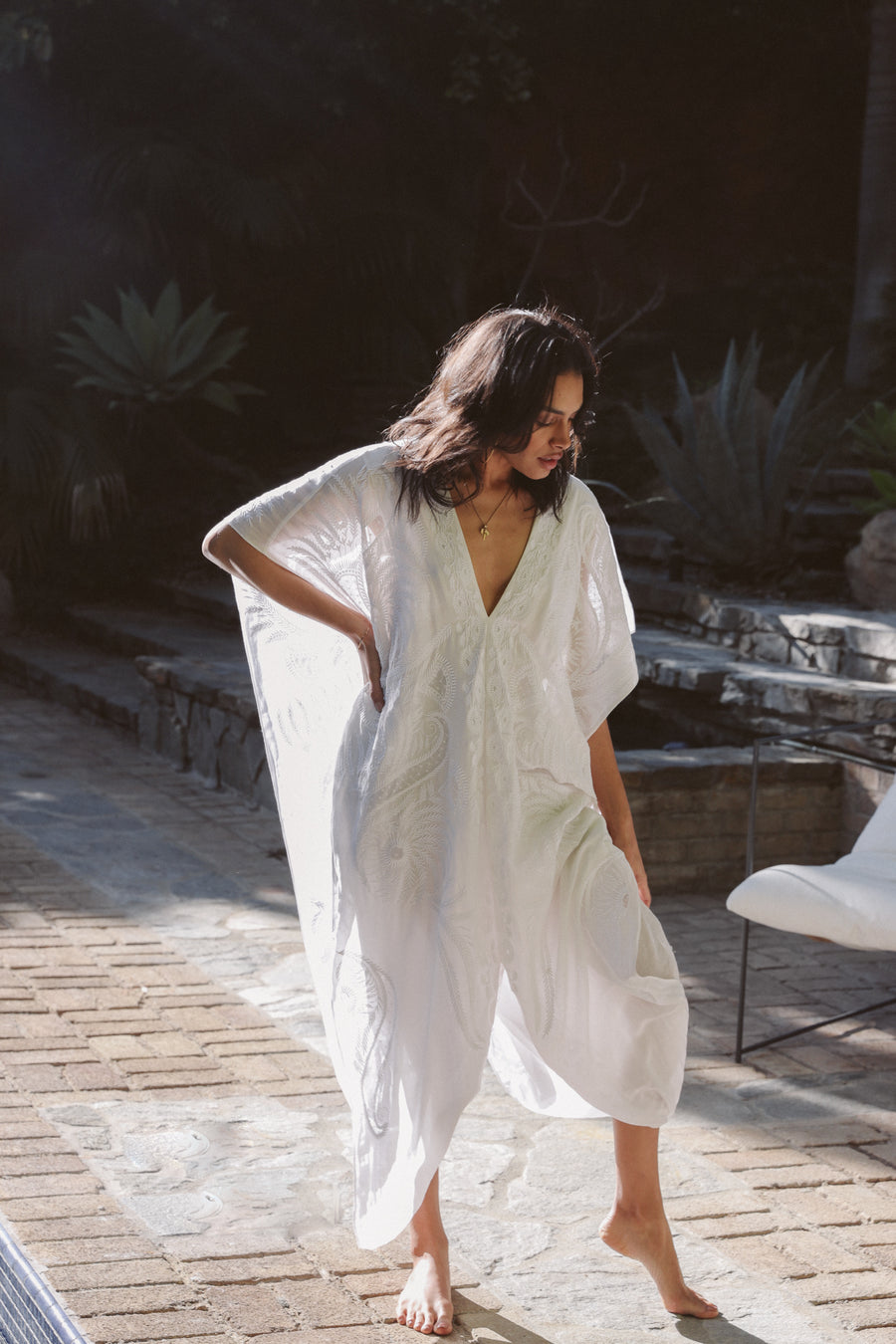 Pull over white embroidered kaftan with deep-v neckline and side opening at waist.