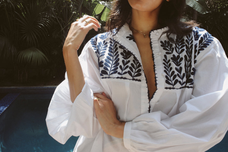 100% pima cotton, easy fitting tunic/coverup in white with pleated voluminous sleeves and blue indigo petal embroidery at the front and back yoke.